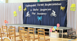 Tablica z napisem Ogólnopolski Turniej Bezpieczeństwa w Ruchu Drogowym etap powiatowy, krzesła oraz znaki drogowe w skrzynce