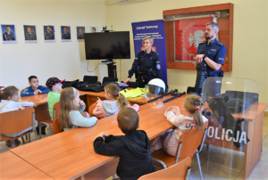 Umundurowani policjanci pokazujący uczniom policyjny sprzęt i umundurowanie
