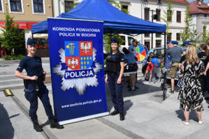 Umundurowane policjantki obok baneru Komendy Powiatowej Policji w Bochni