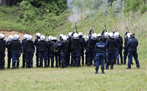 Policjanci w białych kaskach podczas wystrzału z broni