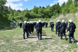 Policjanci idący w kierunku tarcz strzelniczych