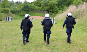 Policjanci idący w stronę tarcz