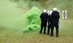 Zielony dym oraz policjanci i tarcze strzelnicze