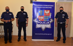 Policjanci oraz baner Komendy Powiatowej Policji w Bochni
