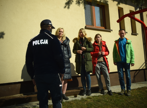 Policjant w trakcie spotkania i rozmowy z trzema kobietami i mężczyzną